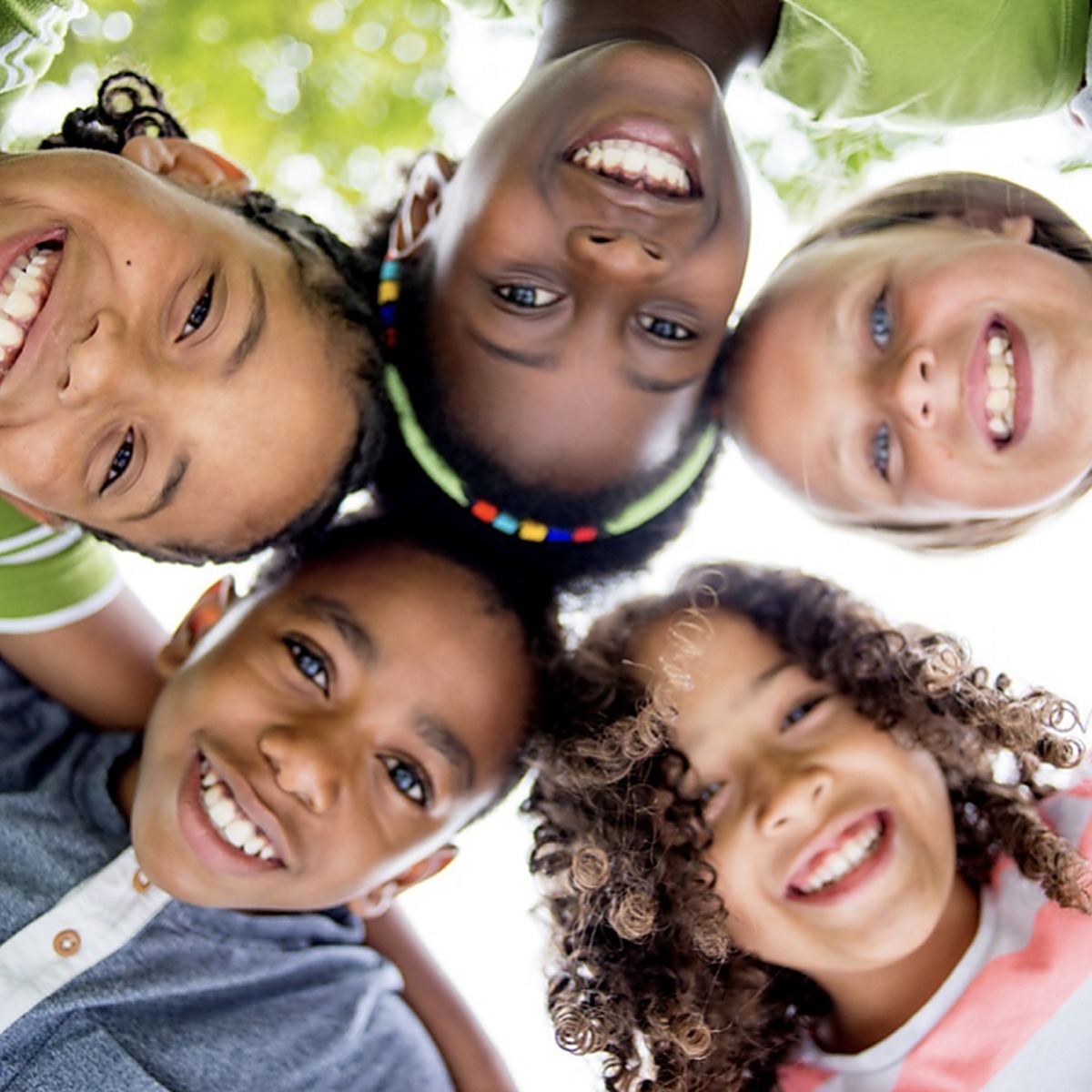 Smiling children huddled together outdoors